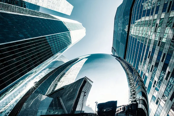 Skyscraper glass facades on a bright sunny day with sunbeams in the blue sky. Modern buildings in Moscow business district La Defense. Bottom up view — Stock Photo, Image