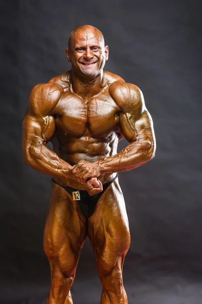 Bodybuilder muskelbygge hans muskler — Stockfoto