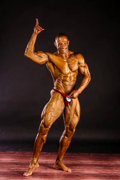 Bodybuilder flexing in studio — Stock Photo, Image