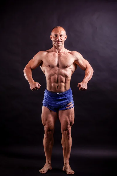 Bodybuilder flettendo i muscoli — Foto Stock