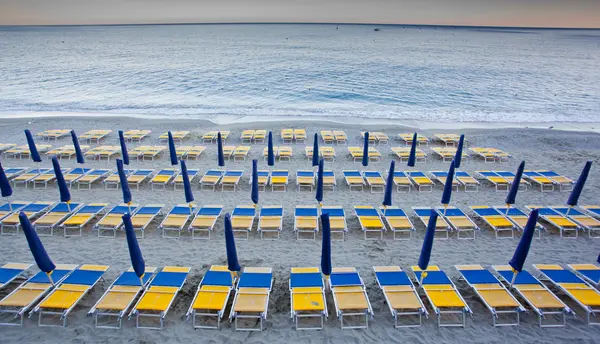 Зонтики на пляже со стульями — стоковое фото