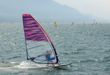 Rüzgar Garda gölünde sörf yapıyor.