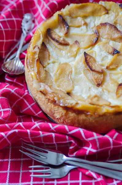 Tarta casera de manzana con una corteza rojiza en el mantel rojo Imagen De Stock