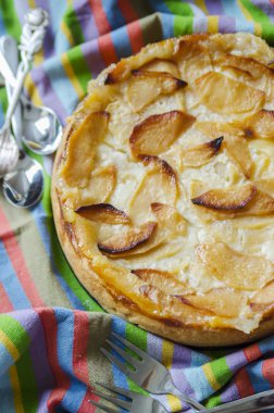 Elma ev yapımı pasta çizgili masa örtüsü üzerinde kırmızı bir kabuk ile