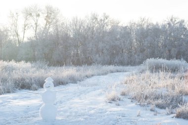 Karlı arazide kardan adam. Siyah ve beyaz. Kocaman gülümseyen kardan adam, mutlu Noeller ve mutlu yıllar tebrik kartı..