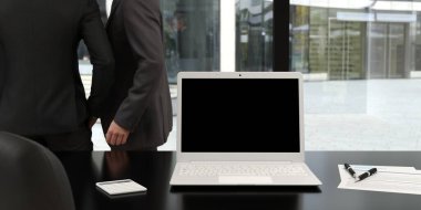 Boş dizüstü bilgisayarı olan modern ofis masası ve arka planda konuşan iş adamları - 3D görüntüleme