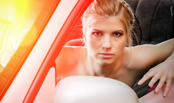 Mujer joven sentada en el asiento de los conductores de su coche — Foto de Stock