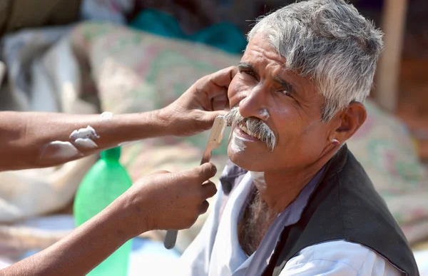 An unidentified man shaves from a street barber at the Pushkar f — Stock Photo, Image