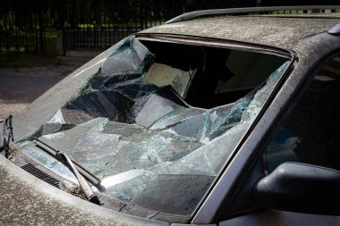 Caddedeki arabanın kırık ön camı.