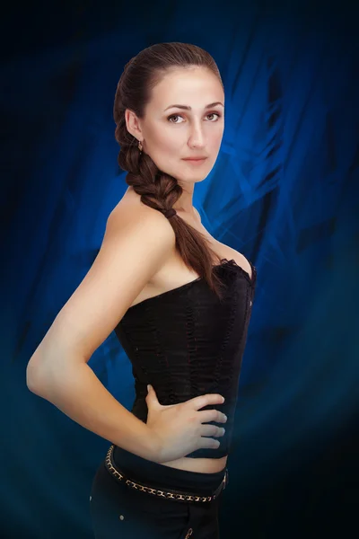 Woman in corset on a blue background — Stock Photo, Image