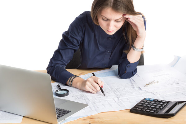 Young female architect working on blueprint