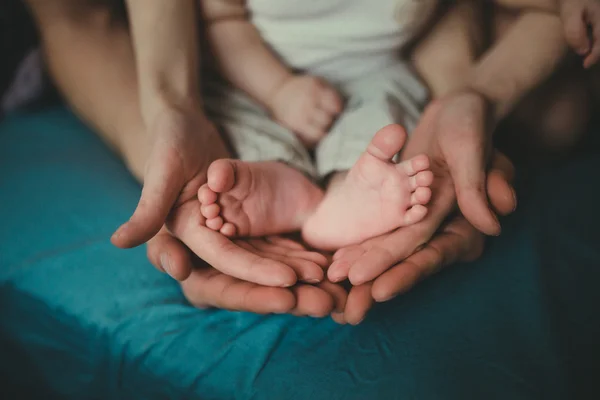 Mani dei genitori interessati bambino a piedi nudi — Foto Stock