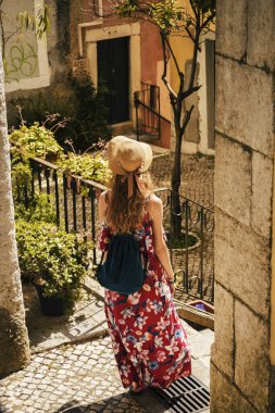 Geniş elbiseli genç bir kadın Avrupa 'nın eski sokaklarını keşfediyor..