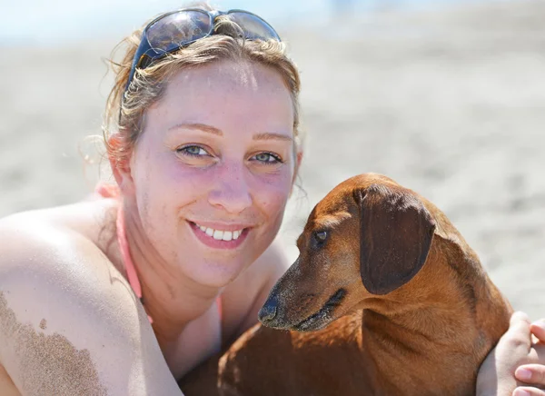 Frau und Hund am Strand — Stockfoto