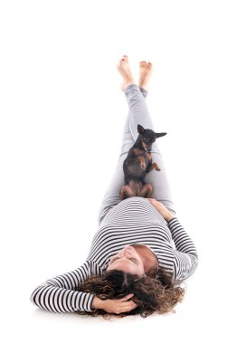 Hamile bir kadın ve beyaz arka planın önünde pinscher.