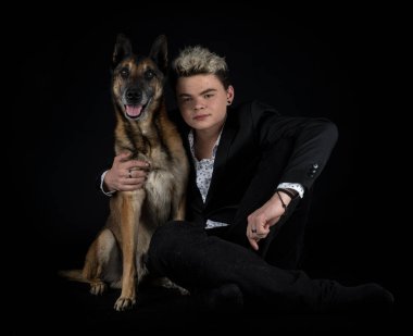 Siyah arka planda Belçikalı çoban ve genç adam.