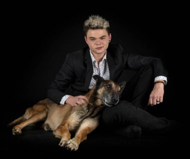 Siyah arka planda Belçikalı çoban ve genç adam.