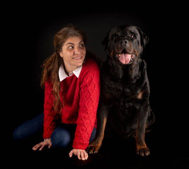 safkan Rottweiler ve siyah arka plandaki kadın