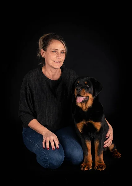 Renrasiga Rottweiler Och Kvinna Framför Svart Bakgrund — Stockfoto