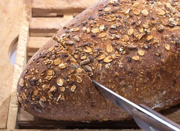 Messer schneidet Vollkornbrot — Stockfoto