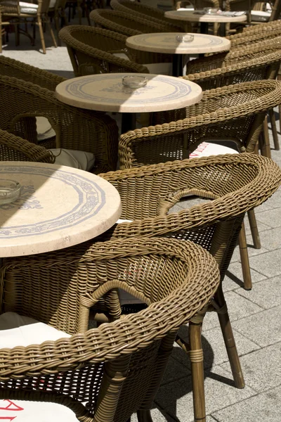 Gatuvy över en tom kaffe terrass med bord och stolar — Stockfoto