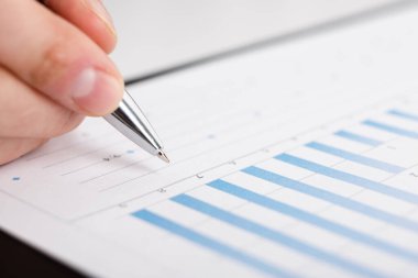 İş adamları şirket verilerini ve istatistiklerini analiz etmek için kalem kullanarak grafikleri gösteriyorlar..