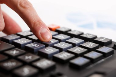 Finansal kavramları olan bir hesap makinesi kullanan iş adamları