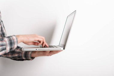 Beyaz arkaplanda insan eli ile izole edilmiş dizüstü bilgisayar