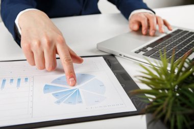 Ofisteki bilgisayarda çalışan bir iş adamı. Belgelerle çalışan erkek muhasebecinin kırpılmış görüntüsü