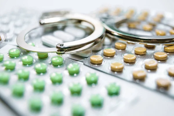 Kelepçe, hap ve uyuşturucu beyaz masada..