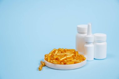 Mavi arka planda altın hap kapsülleri. Pahalı tıbbi bakım veya teşhis kavramı.