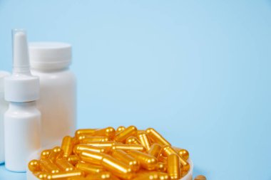 Mavi arka planda altın hap kapsülleri. Pahalı tıbbi bakım veya teşhis kavramı.