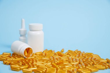 Mavi arka planda altın hap kapsülleri. Pahalı tıbbi bakım veya teşhis kavramı.