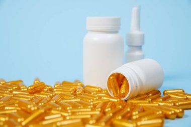 Mavi arka planda altın hap kapsülleri. Pahalı tıbbi bakım veya teşhis kavramı.