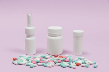 Mavi ve beyaz kapsül hapları beyaz plastik şişelerden döküldü. Küresel sağlık hizmeti kavramı. Antibiyotik ilaç direnci. Antimikrobik kapsül hapları. İlaç sanayisi. Eczane.