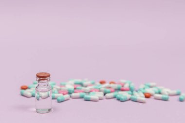 Pembe arkaplanda fotokopi alanı olan ilaç ve iğne şişesi