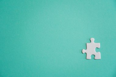 Kayıp yapboz parçaları. İş konsepti. Katlanmış beyaz yapboz parçası ve renkli bir yüzeyin arka planına karşı taranmamış bir yığın yapboz..