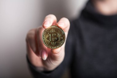 Kadın elinde altın Bitcoin, yeni sanal para biriminin dijital sembolü. Kadın Bitcoin işinden para almış..