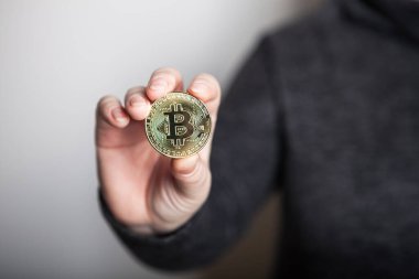 Kadın elinde altın Bitcoin, yeni sanal para biriminin dijital sembolü. Kadın Bitcoin işinden para almış..