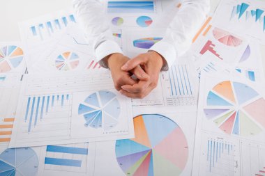 İş kadını, grafik belgesine yakından bakıyor. Ofis masasında otururken finansal şema, grafik ve iş çizelgeleri gösteren genç bir iş kadını.