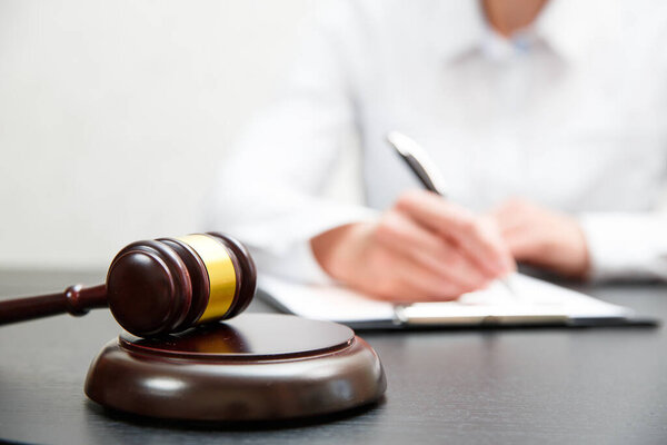 Судья молоток с адвокатами юстиции, собирающими команду в юридической фирме на заднем плане. Понятия права.