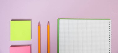 Pembe çalışma alanındaki ofis malzemeleri. Metni kopyalamak için üst görünümü kullan. Desenci çalışma alanı düz masa üzerinde temel elementler yatıyordu