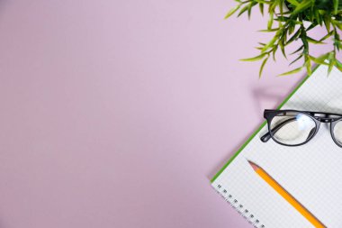 Pembe çalışma alanındaki ofis malzemeleri. Metni kopyalamak için üst görünümü kullan. Desenci çalışma alanı düz masa üzerinde temel elementler yatıyordu