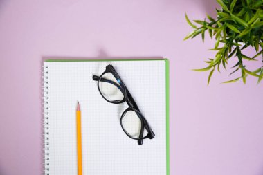 Pembe çalışma alanındaki ofis malzemeleri. Metni kopyalamak için üst görünümü kullan. Desenci çalışma alanı düz masa üzerinde temel elementler yatıyordu