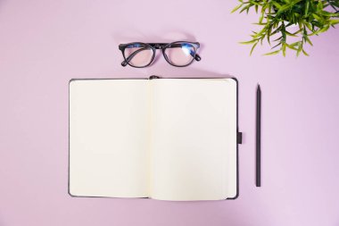 Pembe çalışma alanındaki ofis malzemeleri. Metni kopyalamak için üst görünümü kullan. Desenci çalışma alanı düz masa üzerinde temel elementler yatıyordu