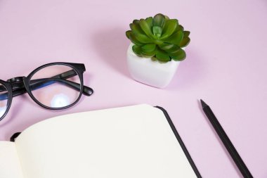 Pembe çalışma alanındaki ofis malzemeleri. Metni kopyalamak için üst görünümü kullan. Desenci çalışma alanı düz masa üzerinde temel elementler yatıyordu