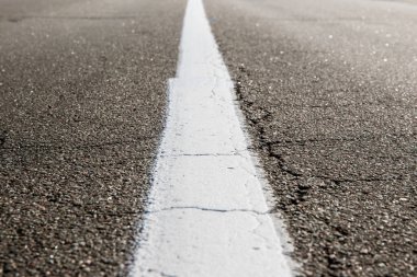 Eski asfalt yolu. Boş bir yolda araba kullanmak. Asfalt yolda beyaz bir çizgi var. Sığ alan derinliği.