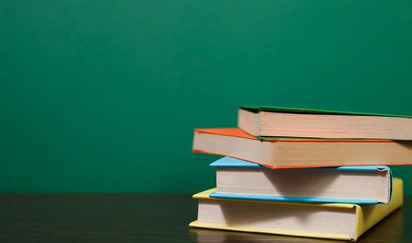 Composition with vintage old hardback books, colored background. Books stacking. Back to school. Copy Space. Education background.