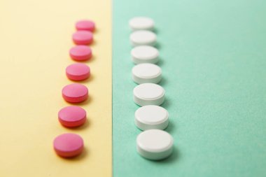Renkli arka planda beyaz ve pembe ilaçlar.