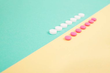 Renkli arka planda beyaz ve pembe ilaçlar.